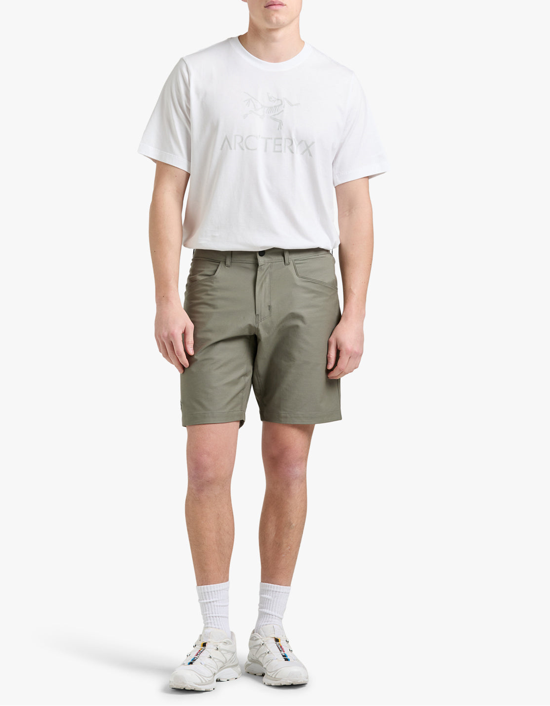 Man wearing a white t-shirt and green shorts on a white background