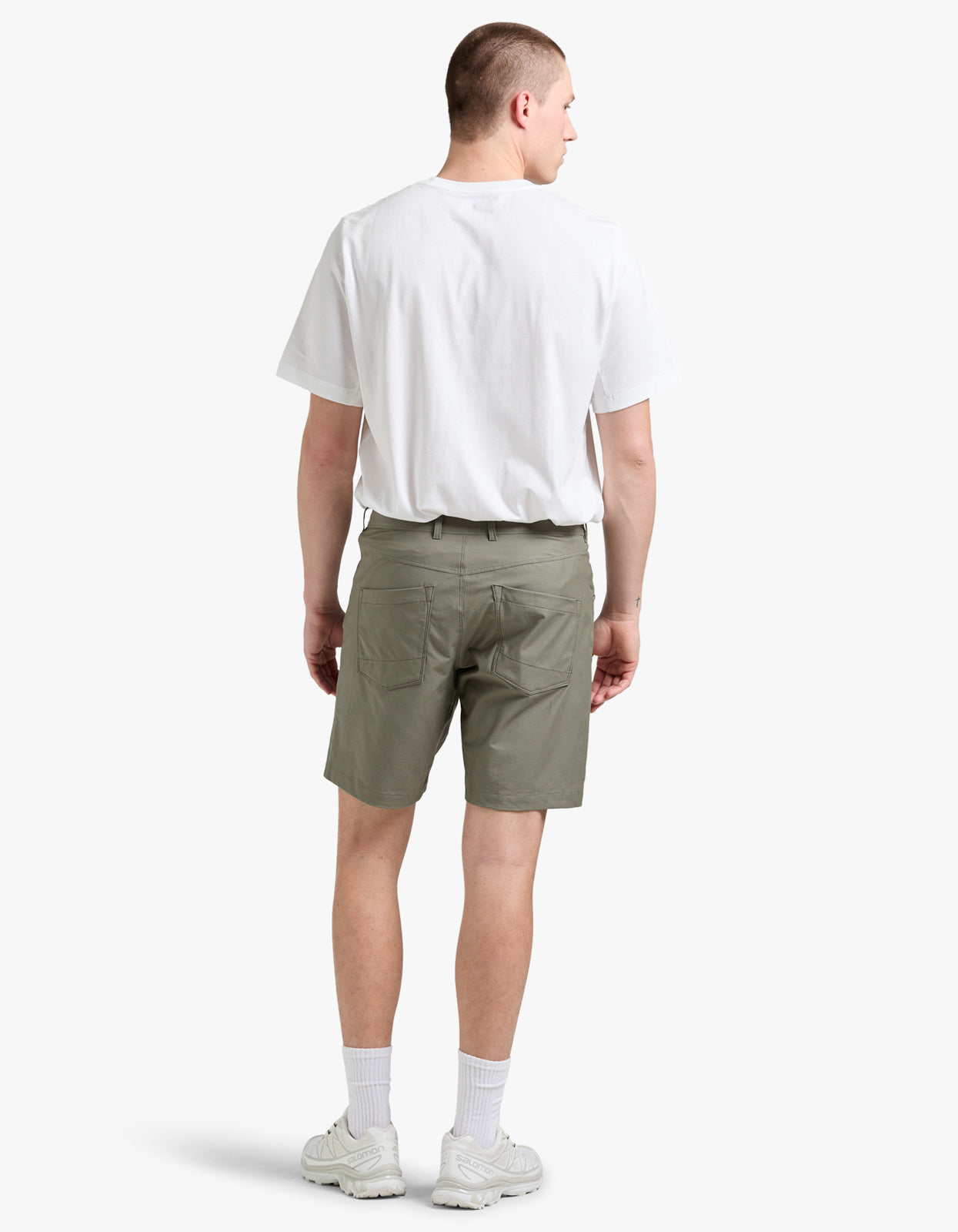 Man wearing a white t-shirt and green shorts on a white background